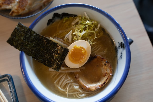 A bowl of ramen with egg and nori for toppings. 