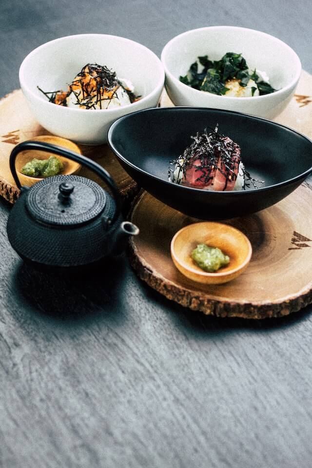 An assortment of Japanese dishes served with Japanese tea and wasabi.