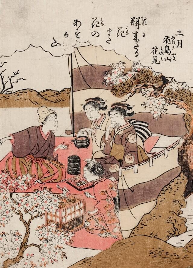 A print of four women chatting and enjoying a meal under the blooming cherry trees