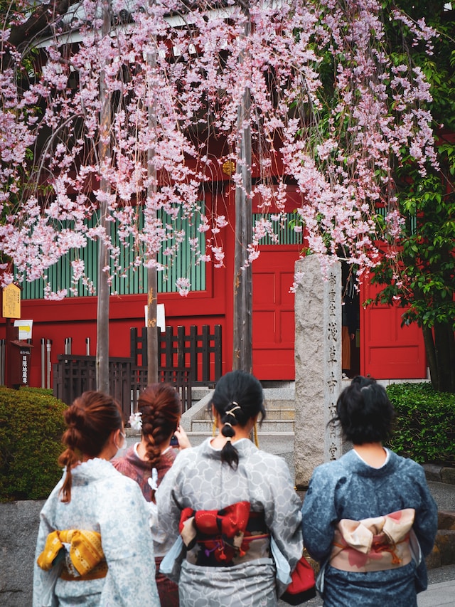 Japanese women wearing kimonos in front of a shrine